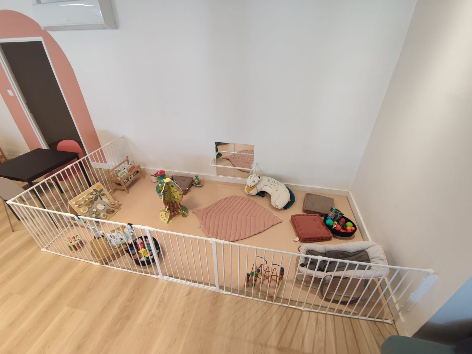 Espace bébé avec parc et jouets au sol